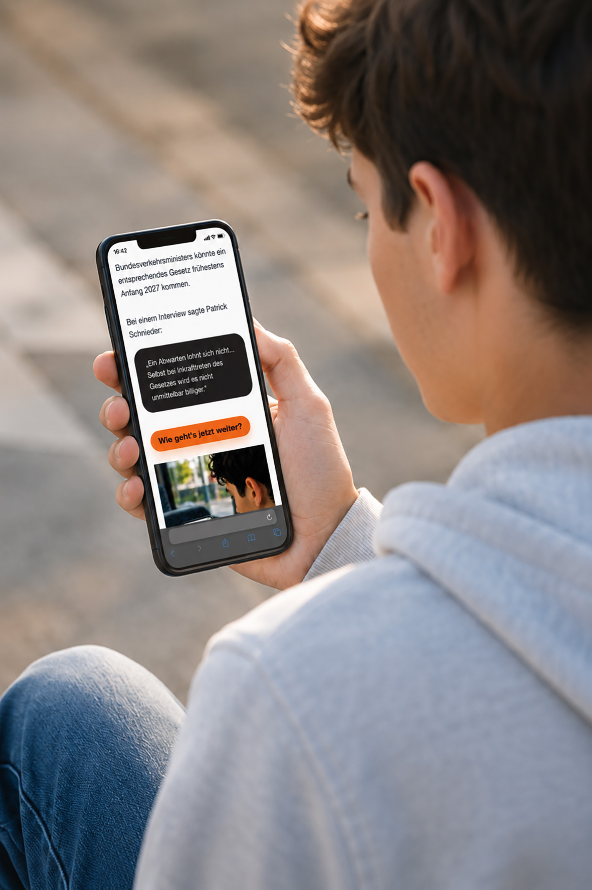 Junger Erwachsener blickt auf ein Smartphone mit Informationen zum Führerschein.